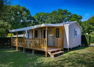 a tiny house with a porch and a deck at Camping 4 étoiles - Parc aquatique - eeiagf in Damgan