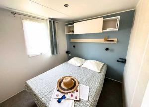 ein Schlafzimmer mit einem Bett, auf dem ein Hut liegt in der Unterkunft Camping 5 étoiles - Parc aquatique - eei0fd in Saint-Jean-dʼOrbetiers