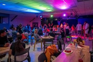 Un grupo de personas sentadas en mesas en una habitación. en Camping 4 étoiles - Parc aquatique - eeiaia, en Olonne-sur-Mer
