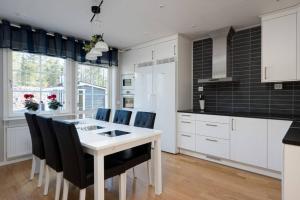 a kitchen with a white table and black tiles at Sauna cabin | Pets allowed | Engine heater in Lofsdalen