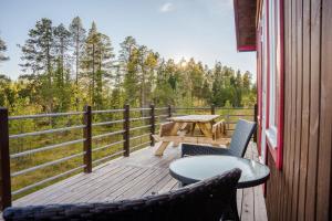 a wooden deck with a picnic table and chairs at Close to ski slopes | Sauna | WiFi | Terrace in Lofsdalen
