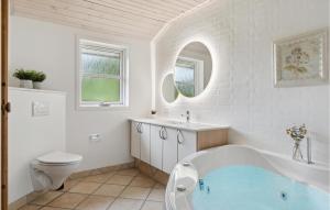 a white bathroom with a tub and a toilet at Casa Fortuna in Bindslev