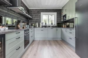 a kitchen with white cabinets and a wooden floor at Sauna | Wi-Fi | Pets allowed | Dryer in Lofsdalen