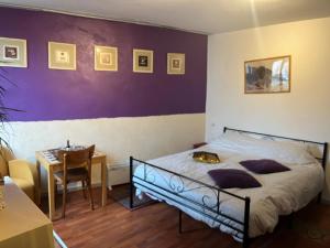 a bedroom with a bed and a table with a chair at La petite maison d issy in Issy-lʼÉvêque