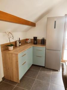 eine Küche mit einem Kühlschrank und einer Holztheke in der Unterkunft La Feclaz - Duplex 90m2 au pied des pistes in Les Déserts