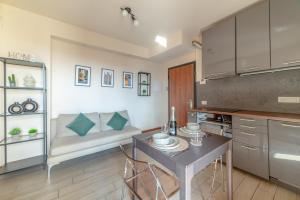 una cucina con tavolo, sedie e un divano di COS54 - Exclusive Apartment - a Milano Altre 7 foto