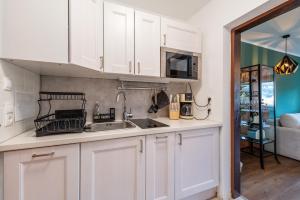 a kitchen with white cabinets and a sink at Peak Moments - by myNests in Aich +11 photos