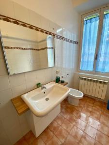 Un baño blanco con lavabo e inodoro. en La Piccola Gioia 1, en Bérgamo