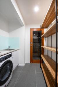 a laundry room with a washer and dryer next to a door at 2BR Home with Outdoor Deck with Beach Nearby M10 in Brisbane +17 photos
