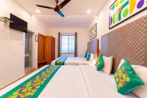 A bed or beds in a room at Treebo Regalia Comforts, 15 Mins From Abbey Waterfall