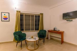 A television and/or entertainment centre at Treebo Regalia Comforts, 15 Mins From Abbey Waterfall