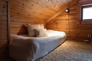 a bedroom with a bed in a wooden room at Ski-in/Ski-out | Sauna | Pets allowed | Terrace in Lofsdalen