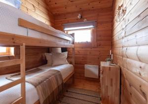 a bedroom with a bunk bed in a log cabin at Ski-in/Ski-out | Sauna | Pets allowed | Terrace in Lofsdalen