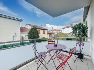 a patio with a table and chairs on a balcony at T2 4 pers Les Cézeaux balcon et parking gratuit in Clermont-Ferrand
