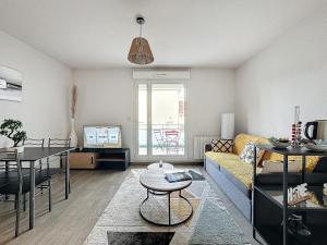 a living room with a couch and a table at T2 4 pers Les Cézeaux balcon et parking gratuit in Clermont-Ferrand