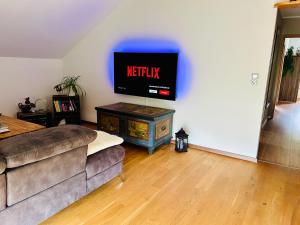 a living room with a couch and a tv on a wall at Ferienwohnung "Bei Freunden" in Naumburg