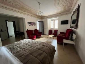 a bedroom with red chairs and a bed in a room at Lercarappart in Lercara Friddi