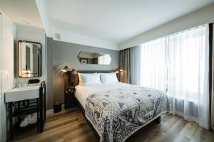 a bedroom with a bed and a sink and a mirror at Pestana Park Avenue in New York