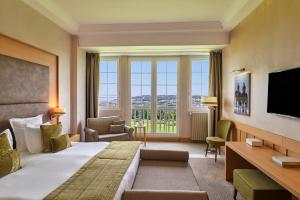 a hotel room with a large bed and a large window at Hôtel Barrière L'Hôtel du Golf in Deauville