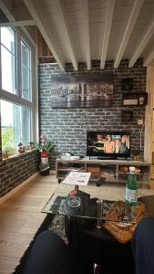 a living room with a tv on a brick wall at Cosy Duplex proche Paris in Épinay-sur-Seine