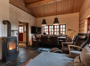a living room with a wood stove and a dining room at Hot tub | Sauna | WiFi | Pets allowed in Lofsdalen