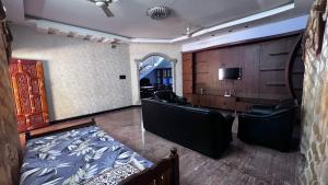 a room with a bed and a desk and chairs at Zeno Villa Malpe - Premium Villa in Malpe