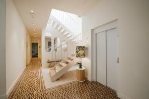 a hallway with white walls and a staircase with a painting at Emblemático F24-Only Adults B&B in Santa Cruz de Tenerife