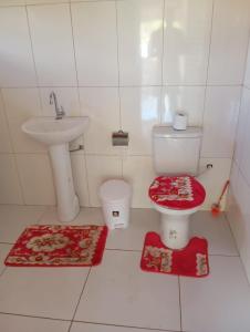 a white bathroom with a toilet and a sink at Paraíso do Sossego Pirenópolis in Pirenópolis