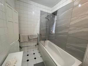 a white bathroom with a tub and a shower at Single room 10 minutes to Central London in London