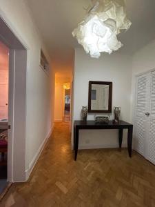 a room with a table and a mirror and a chandelier at Single room 10 minutes to Central London in London +5 photos