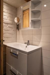 a white bathroom with a sink and a mirror at Sauna | WiFi | Fireplace in Lofsdalen