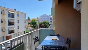 a balcony with a table and chairs on a balcony at Spacieux T3 Sète, parking, 10 min à pied gare et centre ville, wifi, clim in Sète