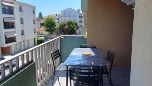 a table and chairs on the balcony of a building at Spacieux T3 Sète, parking, 10 min à pied gare et centre ville, wifi, clim in Sète +34 photos