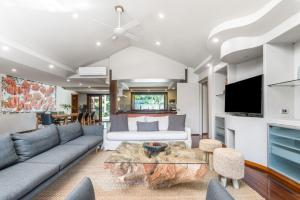 a living room with a couch and a table at Cape Byron Suite 2, 3 with Private lounge in Byron Bay