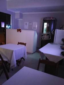 a dining room with two tables and a refrigerator at Pousada Oliveira in Munhoz +19 photos