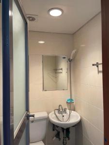 a bathroom with a sink and a toilet and a mirror at GwangJu SunFlower Hostel in Gwangju