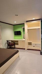 a bedroom with a bed and a green wall at The Haven Sabi in Bangkok