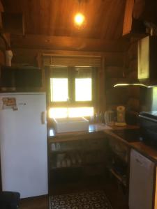 a kitchen with a white sink and a window at Un Chalet en Corrèze in Auriac