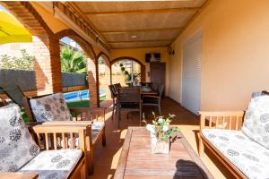 eine Außenterrasse mit Stühlen und einem Tisch und ein Esszimmer in der Unterkunft Catalunya Casas Cozy beach town villa for 8 - no car necessary! in Pineda de Mar