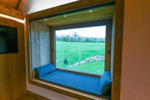 a window seat in a room with a view of a field at Cinque Sensi Wellness Apartments in Braz