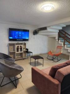 Casa turística contemporánea في بوكارامانغا: غرفة معيشة مع أريكة وكراسي وتلفزيون بشاشة مسطحة +36 صورة