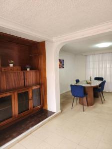 Casa turística contemporánea في بوكارامانغا: غرفة طعام مع طاولة وكراسي زرقاء