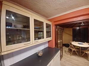 a kitchen with white cabinets and a table in a room at The Rushdon in Grays Thurrock