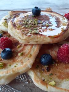 a plate of pancakes with berries on it at Villa Nady in Pauillac