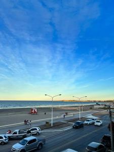 eine stark befahrene Autobahn mit am Strand geparkten Autos in der Unterkunft Boulevard 10 - Dúplex frente al mar con balcón y vista panorámica in Puerto Madryn