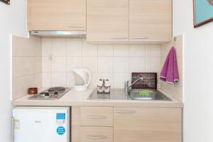 a small kitchen with a sink and a refrigerator at The Castle House Kea in Ioulida