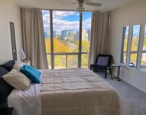a bedroom with a bed and a large window at Cherry Creek Condo in Denver