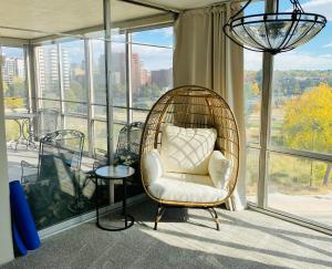 a rattan chair in a room with a large window at Cherry Creek Condo in Denver