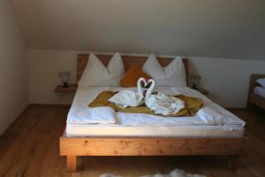 a bed with white sheets and a stuffed animal on it at Rebenchalet in Sankt Anna am Aigen