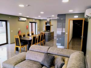 a living room and kitchen with a couch and a table at Casa do Pomar in Vouzela